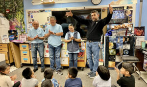 First grade students applaud for the custodians