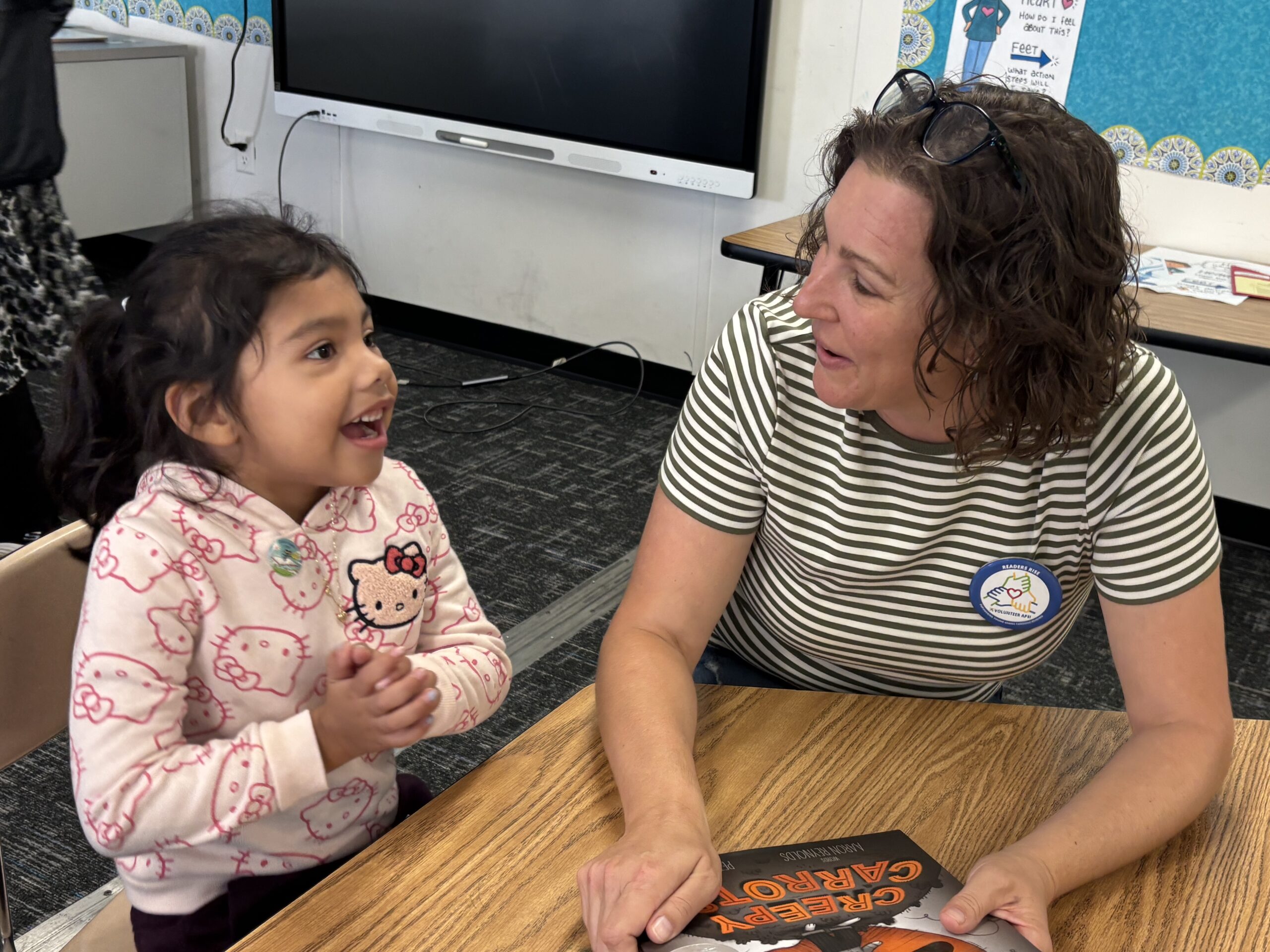 Student with volunteer holding a book
